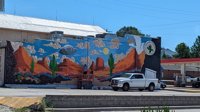 Breeze on a lift putting the finishing touches on the mural.