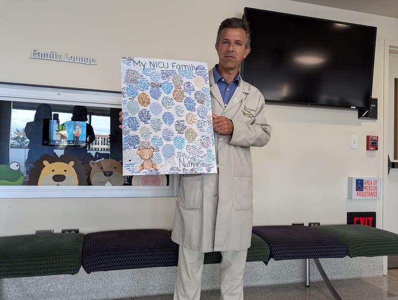 NICU doctor holds up card