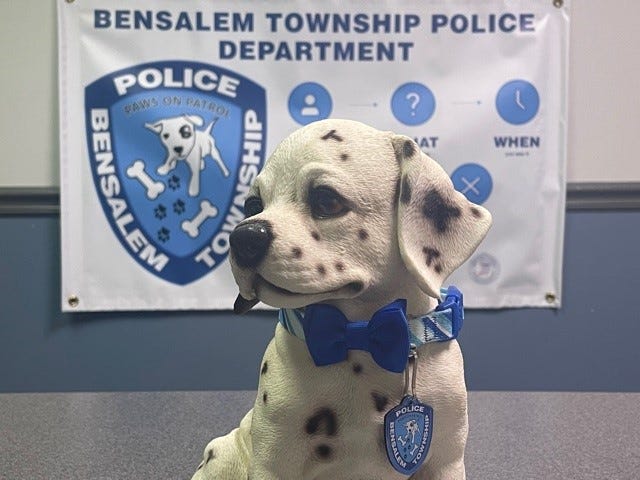 The Bensalem Township Police Department's "Paws on Patrol" mascot, in front of a sign for the program.