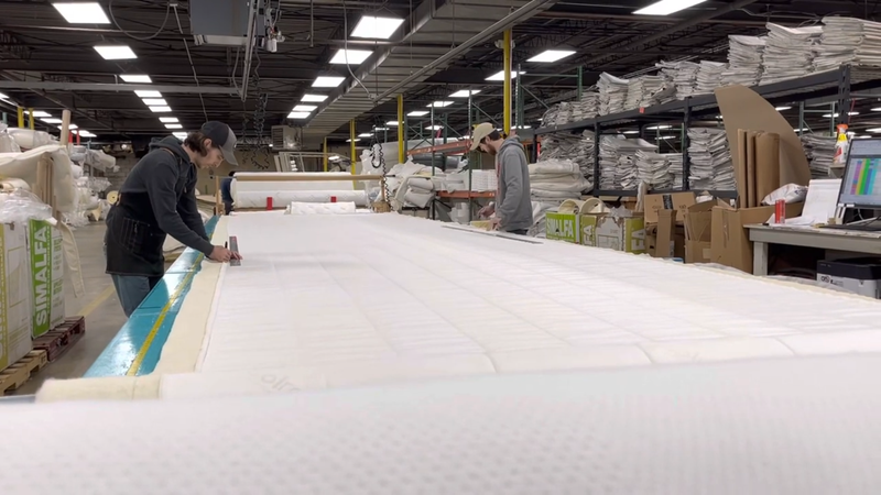 Mattress fabrics and quilts being measured and marked in order to later be cut to size