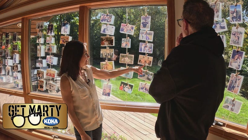 Bea Gelman shows Marty the wall of photos for an upcoming remembrance celebration for Bruce.