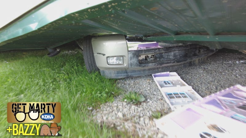 Pickup truck underneath a destroyed home