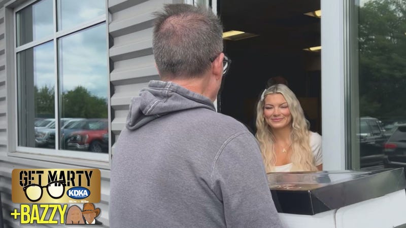 Arianna Bazzy greets Marty Griffin at the door to deliver her dad's surprise cake.