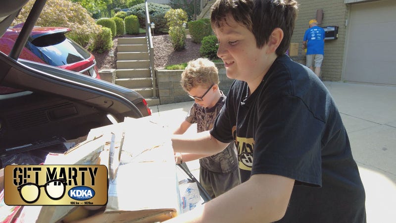 Vince Griffin and Eli Gerhardt help load boxes of balls into Marty's car.