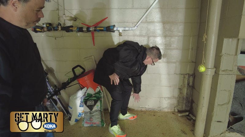 Marty Griffin shows Bud Norton where water is coming into his basement.