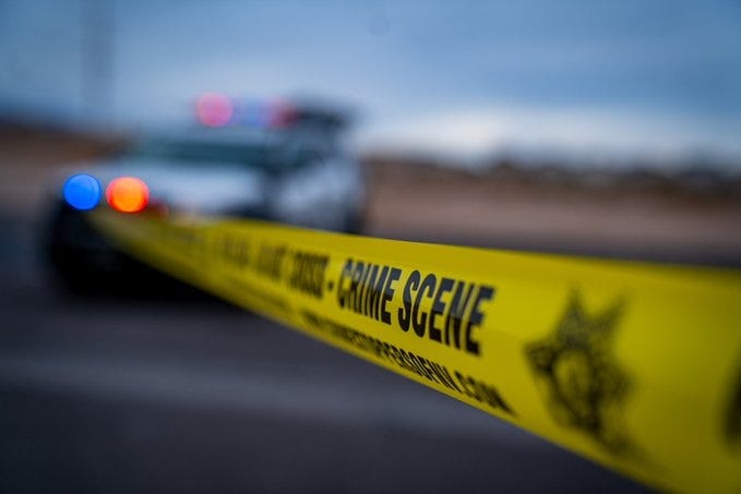 Yellow tape surrounds a crime scene investigation