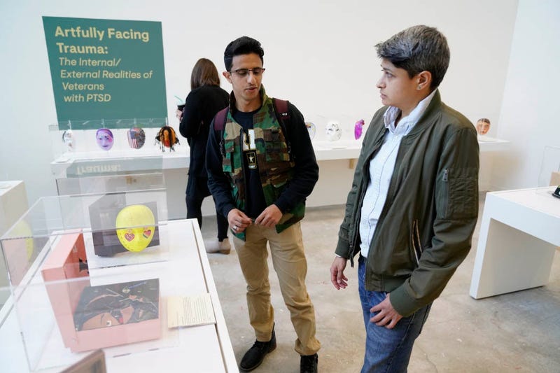 Road Home Program participants walk through an art exhibit centered around PTSD