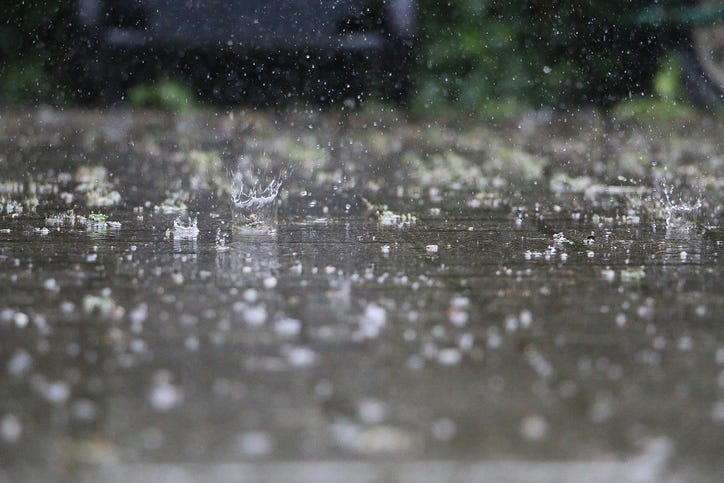 Rain falls onto pavement