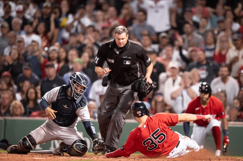 Red Sox First Baseman Eric Hosmer slides home safely on a sacrifice fly in the 4th inning against the Yankees Saturday night in Boston.