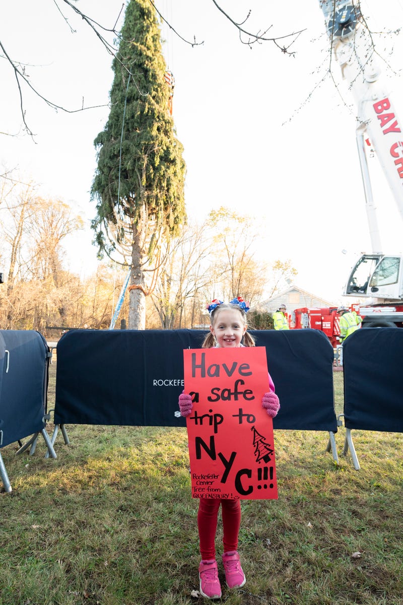 Delaney, 6, holds a sign wishing the tree safe travels to Manhattan, where it will arrive Nov. 10