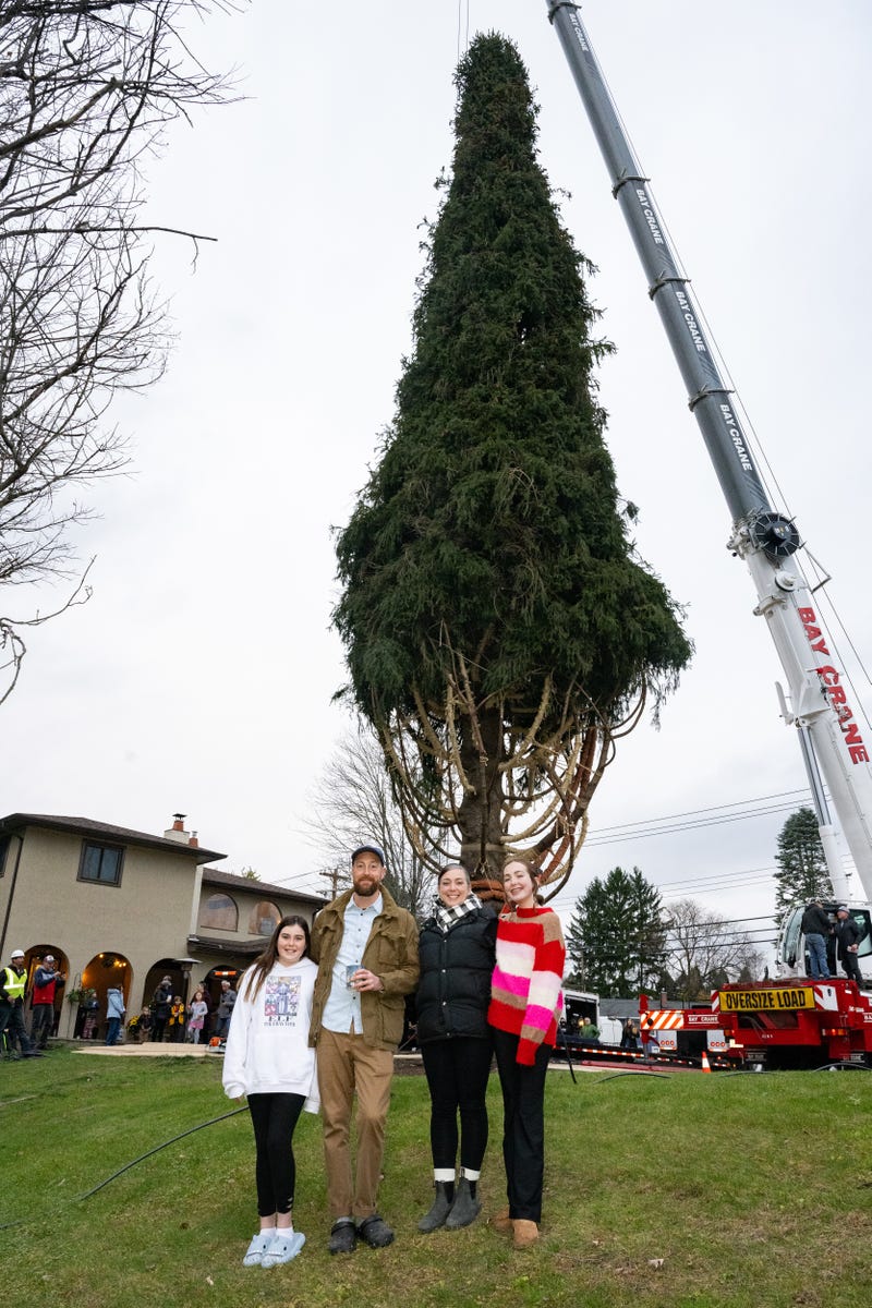Jackie and Matt McGinley pose with their children Charlie and Zooey in front of the wrapped 80-foot tall Norway Spruce that their family donated to serve as this year's Rockefeller Center Christmas Tree,  Thursday, Nov. 9, 2023, in Vestal, NY