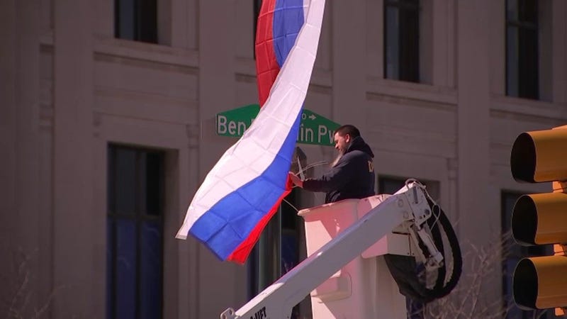 A Russian flag being placed in the location where someone had taken one down Friday morning and replaced it with a Ukrainian one.