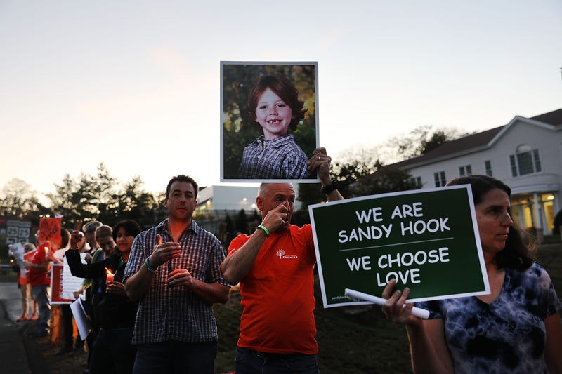 Mark Barden holds up a picture of his son Daniel, who was killed in the Sandy Hook shooting, during a vigil remembering the 59 people killed in a Las Vegas shooting and calling for action to stop gun violence on October 4, 2017 in Newtown.
