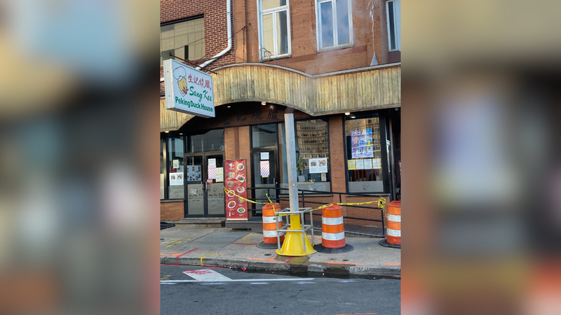 Caution tape cordons off the Sang Kee Peking Duck House entrance as steam pumps out of a pipe on the sidewalk.