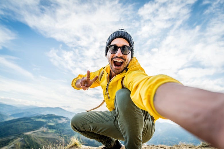 Guy taking selfie on top of mountain