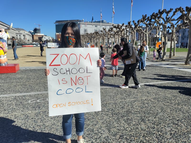 A parent protests, demanding SFUSD reopen classrooms to students.
