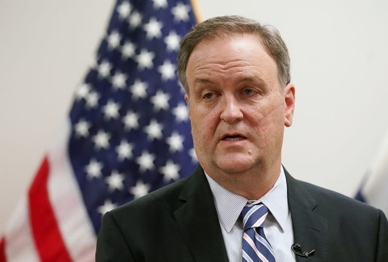 Sam Page in front of an American flag.
