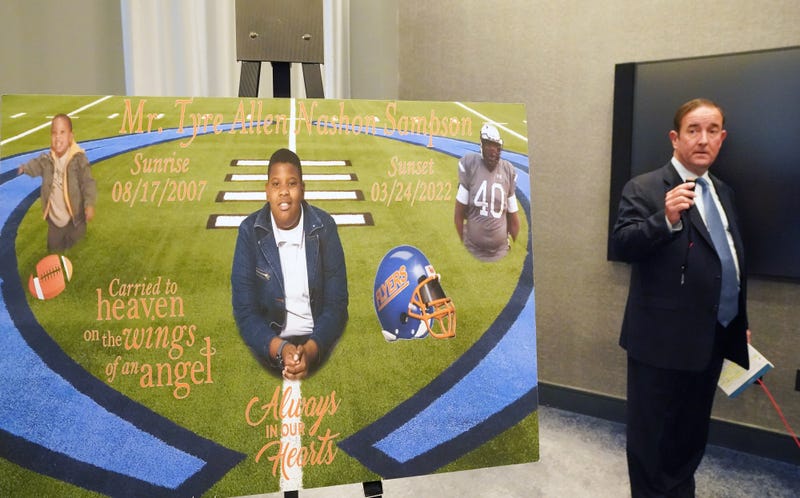 Attorney Michael Haggard displays a $22 seat belt as a sign of Tyre Sampson is displayed following a press conference announcing a wrongful death lawsuit filed on behalf of the family of Sampson in St. Louis on Tuesday, April 26, 2022.