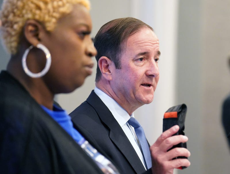 Attorney Michael Haggard displays a $22 seat belt as mother of Tyre Sampson, Nokia Dodd stands near during a press conference announcing a wrongful death lawsuit filed on behalf of the family of Sampson in St. Louis on Tuesday, April 26, 2022.
