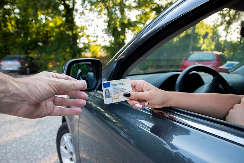 woman handing license to police