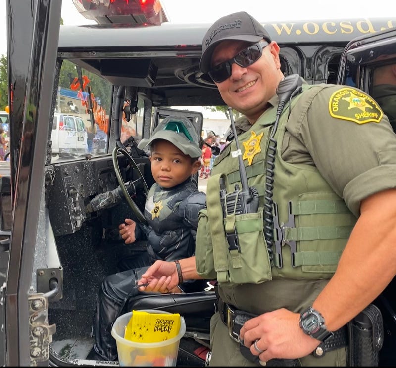 KNX Hero of the week, Orange County Deputy Pete Chavez Trick-or-treating with kids from the community.