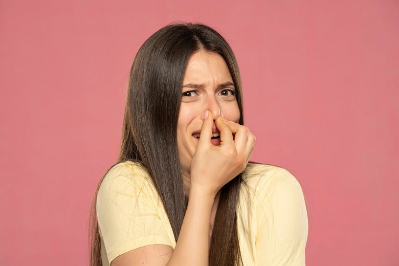woman holding her nose