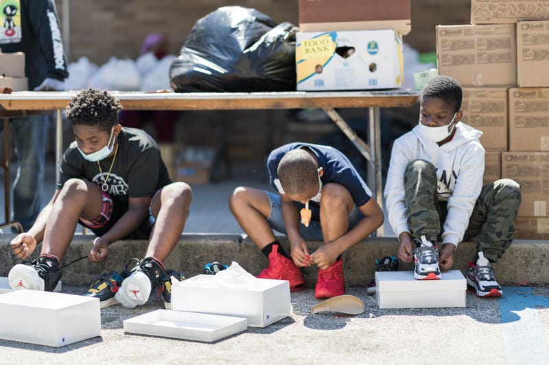 Kids at a summer kick-off event try on shoes.