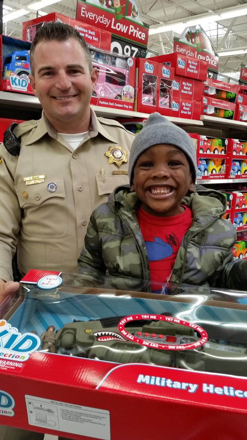 A Metro Police officer helps a child shop for a toy during the 'Santa Cops' event