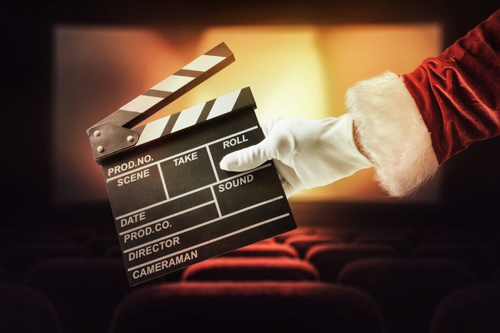 A clapper board held by an arm that appears to be Santa's