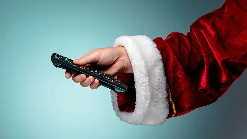 Santa's hand holding a tv remote