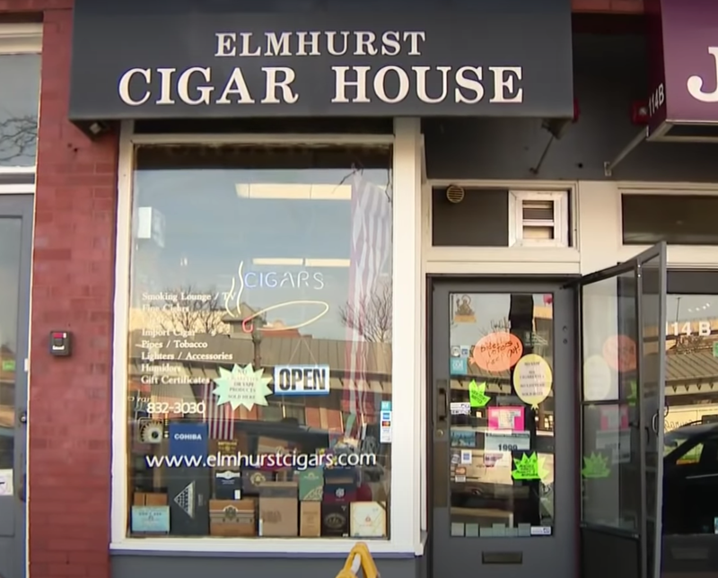 An orange sign on the door of the Elmhurst Cigar House reads “Biden voters keep out!”