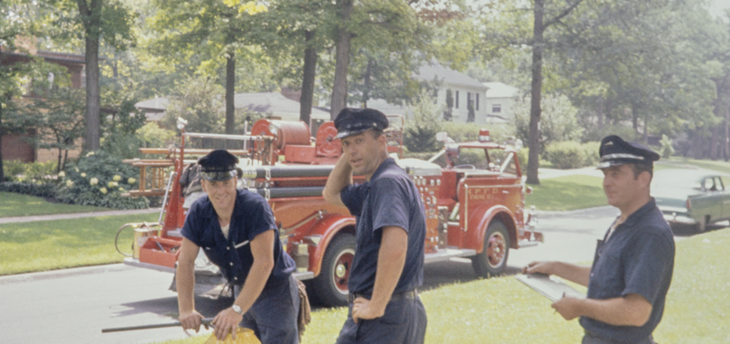 Three fireman from the Highland Park Fire Department are pictured inspecting a fire hydrant on the streets of Highland Park, Illinois, circa 1964.