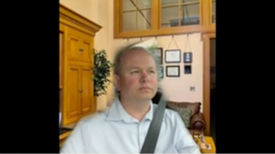 Ohio State Senator Andrew Brenner (19th District), as seen participating on a government Zoom call on Monday with a virtual office background while he drives.