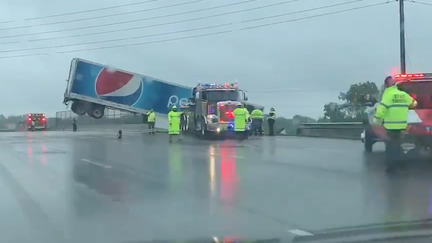 PHOTOS: Tractor-trailer driver rescued hanging off highway