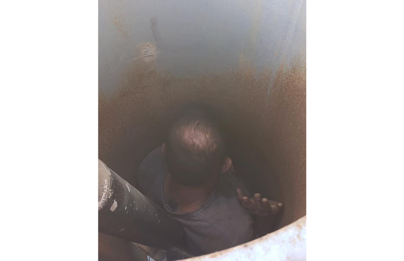 An overhead shot of the man trapped inside the shaft of a vineyard fan.
