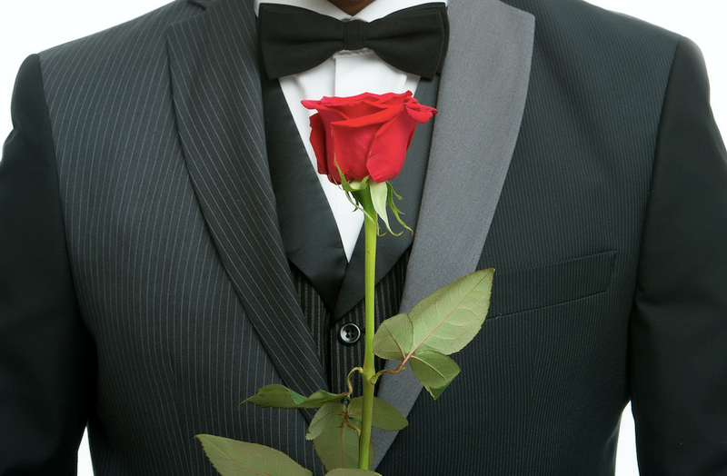 Man in tux holding a rose