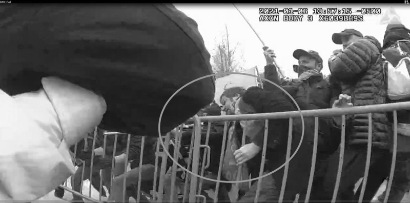 Neumann allegedly using the barricade as a "battering ram" towards a Capitol police officer.