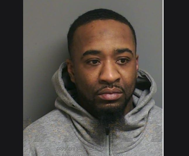 Suspect mugshot wearing grey hoodie