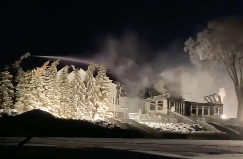 A building destroyed by fire being sprayed by fire hose