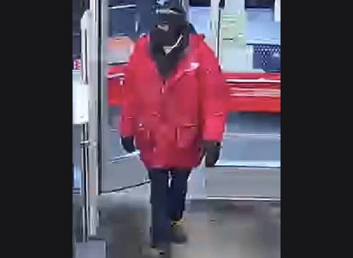 Man wearing red winter coat and black ski mask