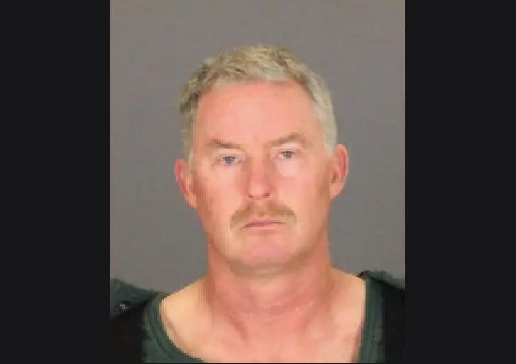 Older man frowning in mug shot