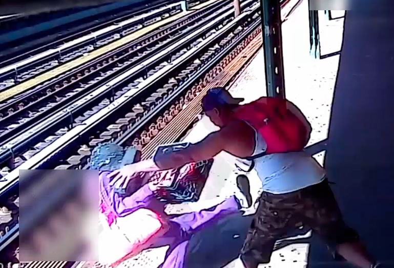 Horrifying video shows the man picking up the woman and then throwing her onto the southbound tracks at the Jackson Avenue subway station on Sunday afternoon