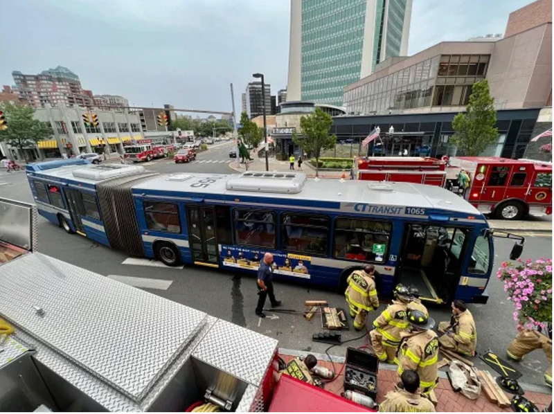 Firefighters rescuing woman under bus
