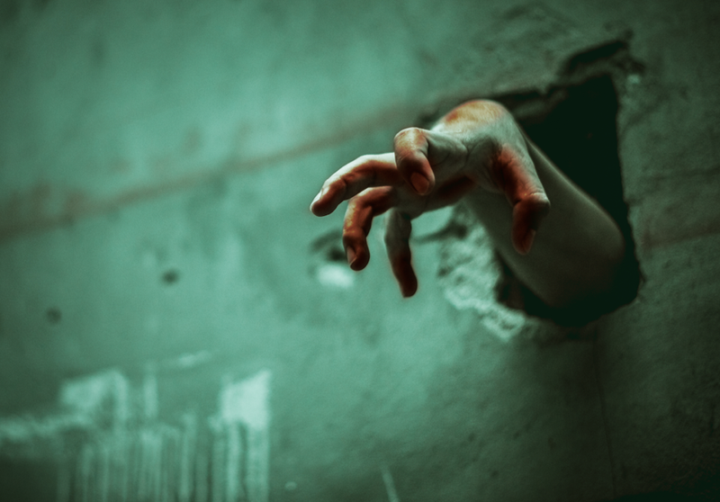 zombie hand emerging through hole