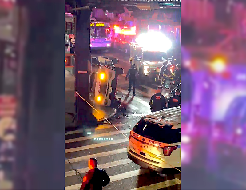 An NYPD cruiser flipped on its side after being struck by a Ford Focus at 111th Street and Liberty Avenue in South Ozone Park on Tuesday night