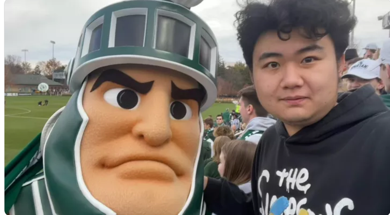 Man with Spartan in front of football field