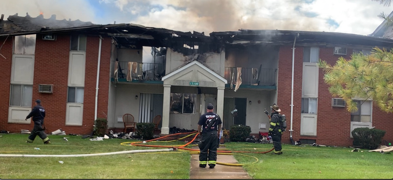 Firefighters standing in front of burning building