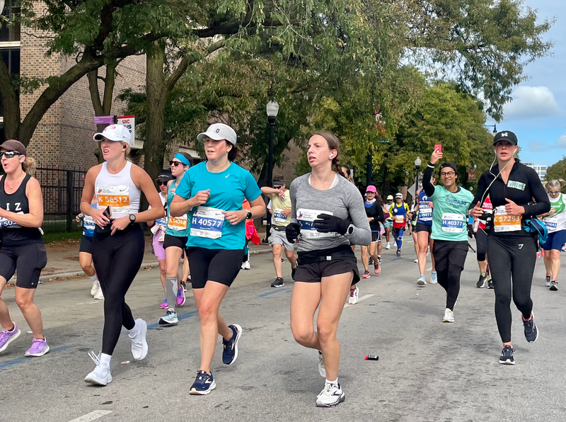 Dozens of runners race along a Chicago street during the Chicago Marathon.