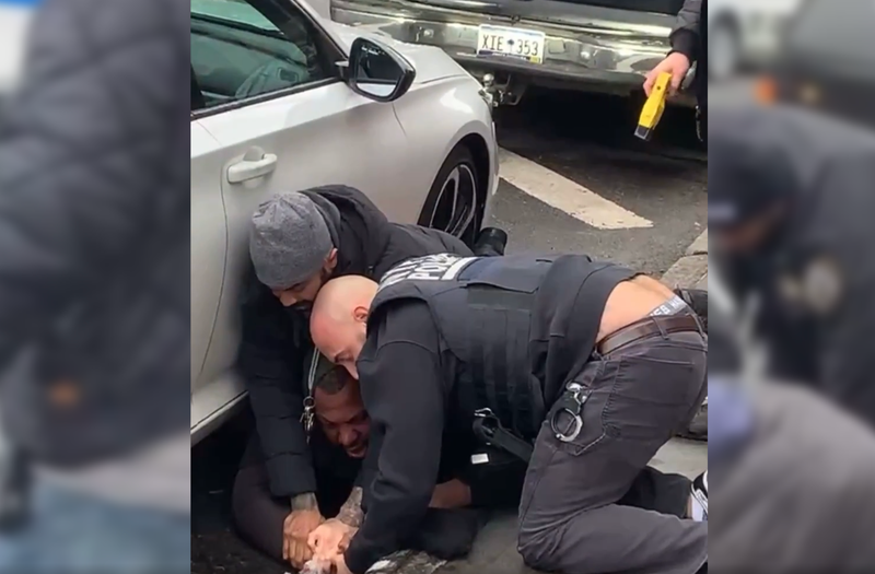 Officers restrain Donald Davis, one using a taser.