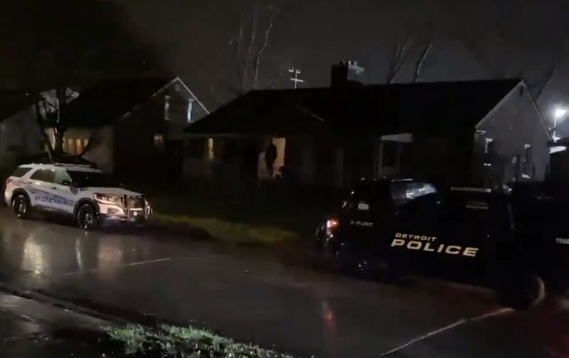 Two Detroit police SUVS outside house at night 